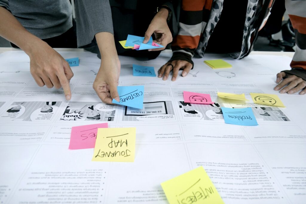 Agile Organisation in der Praxis: Team sortiert Aufgaben mit Klebezetteln an der Wand