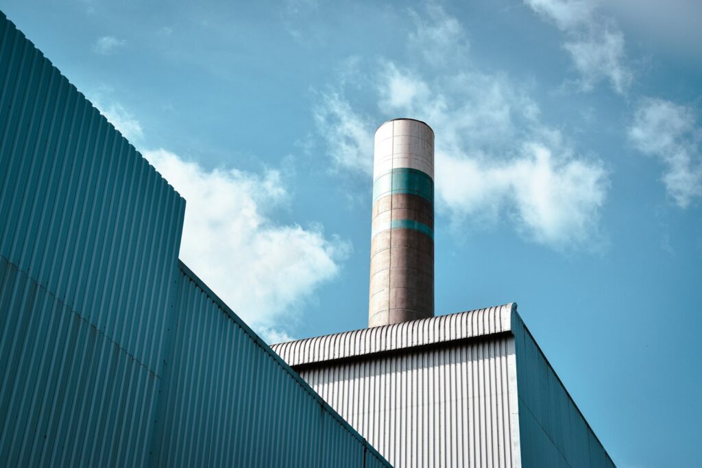 Energiepreise belasten die Industrie: Fabrikgebäude mit hohem Schornstein