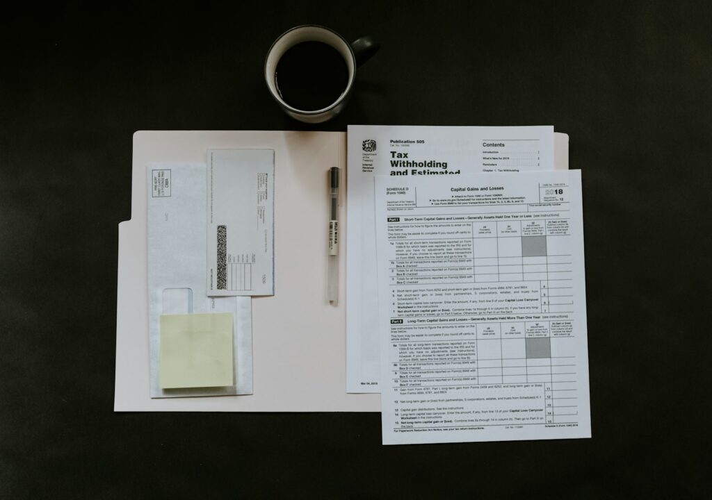 Factoring vorbereiten: Rechnungsformulare, Stift und Kaffeetasse auf dem Schreibtisch