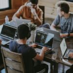 Team arbeitet gemeinsam an Laptops
