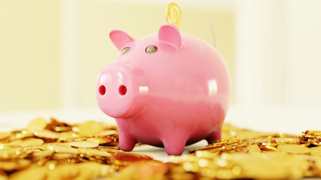 Tagesgeld als Notgroschen: Sparschwein mit Goldmünzen auf hellem Untergrund