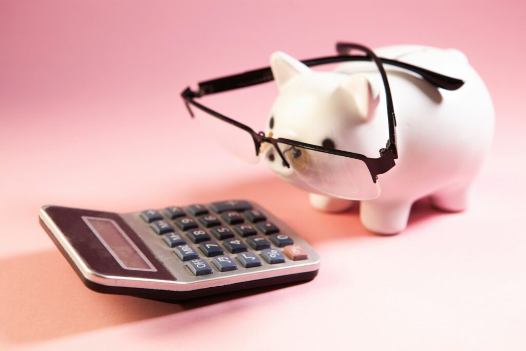 Sparschwein mit Brille neben Taschenrechner beim Vergleich von Zinsen auf Tagesgeldkonten