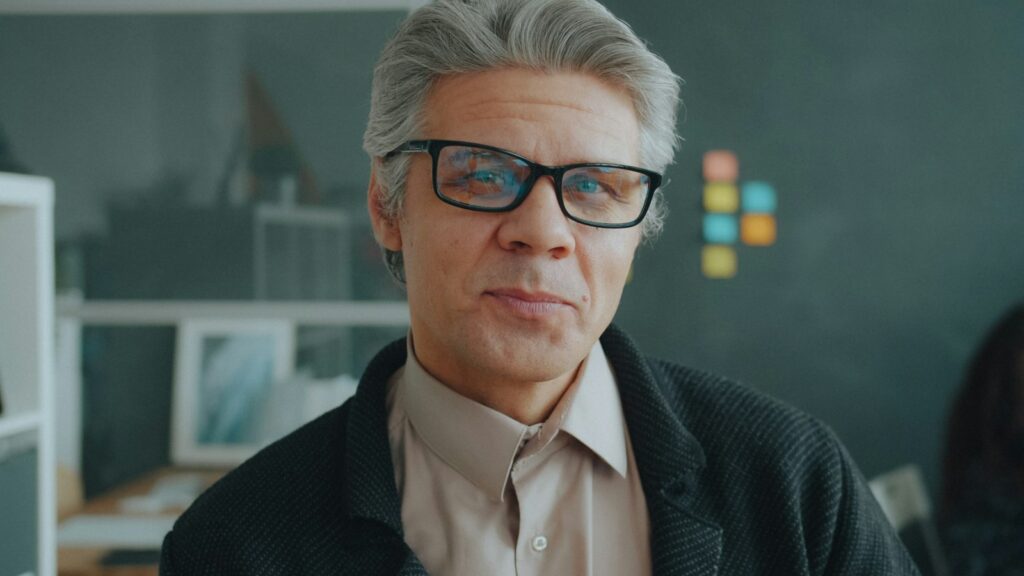 Porträt eines grauhaarigen Unternehmers vor der Betriebsübergabe an die nächste Generation
