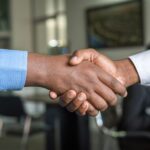 Zwei Personen besiegeln eine Vereinbarung per Handschlag