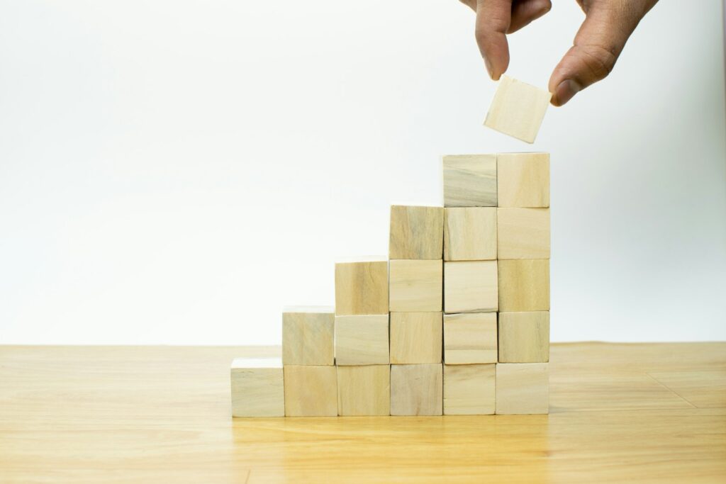 Holzklötze werden zu einer Pyramide gestapelt als Bild für einen stufenweisen Finanzierungsmix